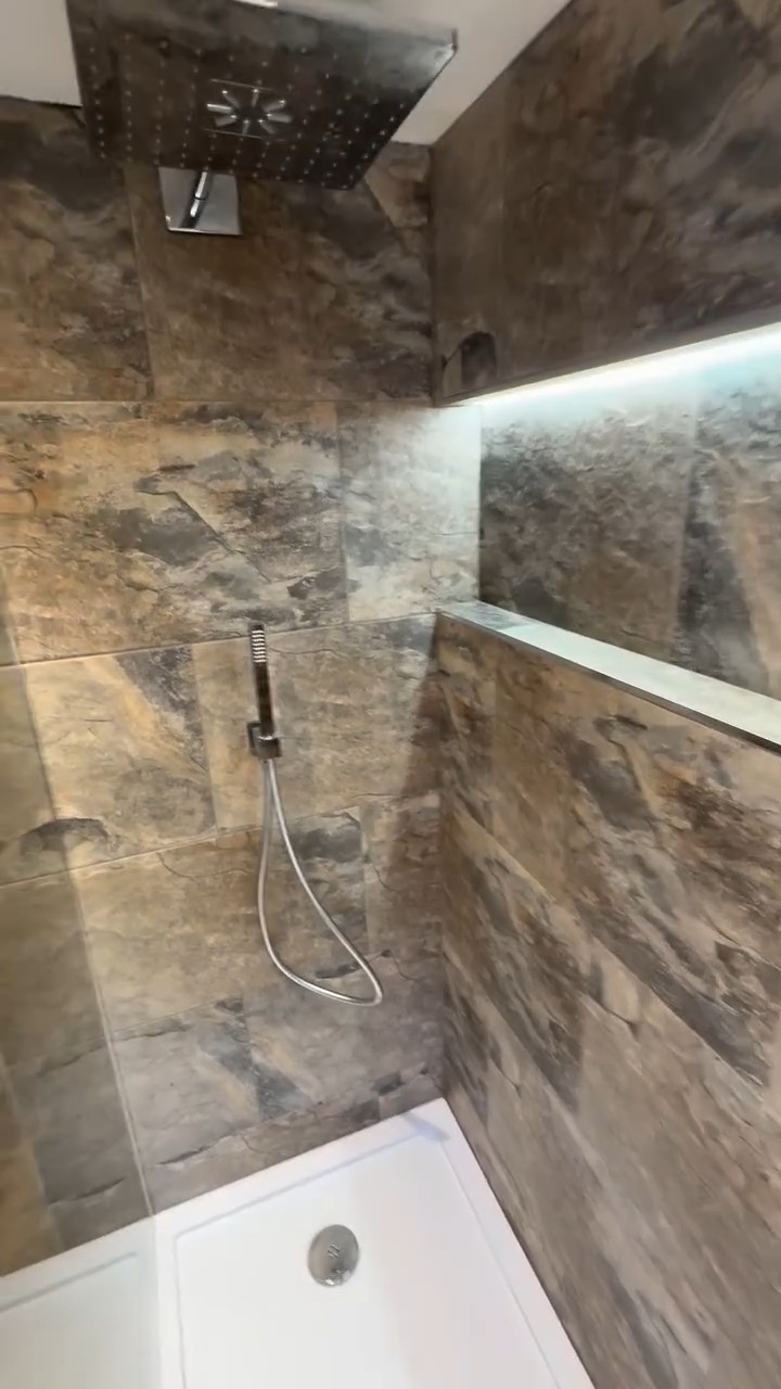 Wall-hung toilet and stone-effect wall tiling